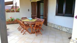 a wooden table and chairs on a patio at Villa Egusa in Favignana