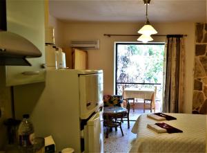 a kitchen with a refrigerator and a room with a table at Apartments Zoumperi in Nea Makri