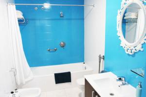 a blue bathroom with a white sink and a mirror at Hugo Beach Hotel & Apartments in Gandía