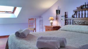 1 dormitorio con 1 cama grande y toallas. en PICO SACRO I HOSTAL-PENSION Santiago de Compostela, en Santiago de Compostela