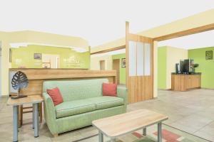 sala de estar con sofá y mesa en Microtel Inn & Suites by Wyndham Tuscumbia/Muscle Shoals, en Tuscumbia