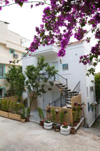 a white building with a staircase and flowers at 8 Pansiyon in Kaş