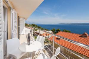 a balcony with a table and chairs and a view of the ocean at Apartments Panorama in Lokva Rogoznica