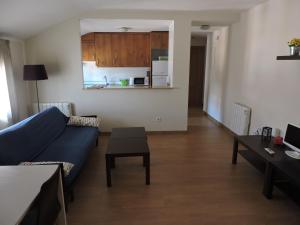 a living room with a blue couch and a table at Apartamento El Rasero in Riaza