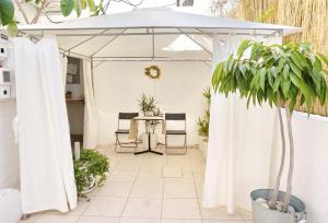 een witte parasol op een patio met planten bij Ilios in Skala