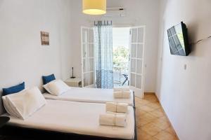 Sala de estar con 2 camas y TV en Ilios en Skala