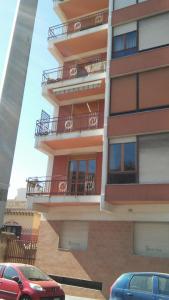 a tall building with cars parked in front of it at B&B PinkHouse in Milazzo