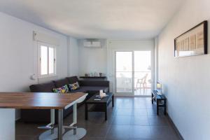 ベナルマデナにあるAmazing panoramic sea views apartmentのリビングルーム(ソファ、テーブル付)