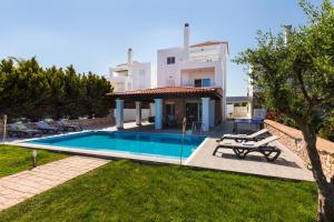 a villa with a swimming pool in front of a house at Gennadi Beach Villas - Waterfront Luxury Retreat with Private Beach in Gennadi