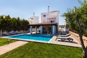 Villa con piscina frente a una casa en Gennadi Beach Villas - Waterfront Luxury Retreat with Private Beach, en Gennadi