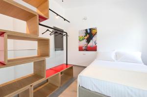 a small bedroom with a bed and a red bench at Votsalo Suites in Skala Potamias +38 photos