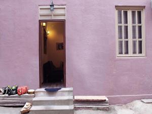 un edificio rosa con puerta y ventana en Old castle Apartment, en Tiflis