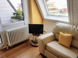ein Wohnzimmer mit einem Sofa und einem TV in der Unterkunft Ferienapartment Seeblick in Meersburg