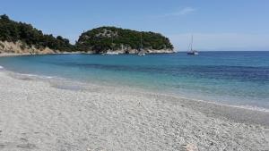a rocky beach with two boats in the water at Kalithea Studios in Stafylos