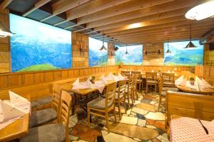 un restaurante con mesas y sillas y una gran ventana en Appartement Alpenfex, en Flachau