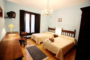 a bedroom with two beds and a chandelier at Hotel Casa de Indianos Don Tomás in Nueva de Llanes