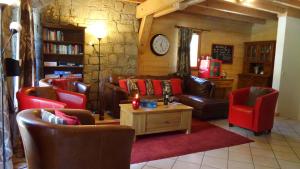 a living room with leather furniture and a stone wall at Chalet Sophia by Chalet Chardons in Tignes