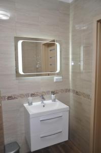 ein Badezimmer mit einem weißen Waschbecken und einem Spiegel in der Unterkunft Apartament Berlin in Świnoujście