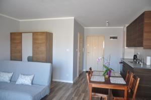 ein Wohnzimmer mit einem blauen Sofa und einem Tisch in der Unterkunft Apartament Berlin in Świnoujście