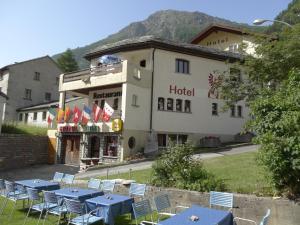 a hotel with tables and chairs in front of it at Hotel-Restaurant Grina in Simplon Dorf
