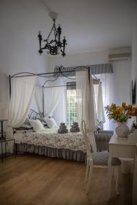 1 dormitorio con cama con dosel, silla y ventana en La Piazzetta delle Regine, en Roma
