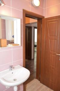 a bathroom with a sink and a mirror and a door at Ivet Apartment in Varna City