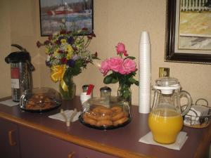 a counter with breakfast foods and orange juice and flowers at Great Lakes Inn Mackinaw City in Mackinaw City