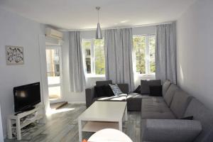 Una sala de estar con un sofá y un televisor. en Ivet Apartment, en Varna