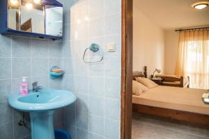 a bathroom with a sink and a bedroom with a bed at Apartmani Ksenija in Petrovac na Moru +153 photos