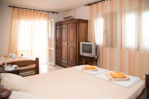 a hotel room with two beds and a tv at Apartmani Ksenija in Petrovac na Moru