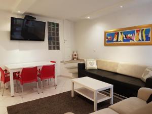 a living room with a couch and a table and a tv at Art House in Poreč