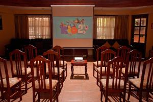 a room with chairs and a screen with a projector at Hotel Mabey Urubamba in Urubamba