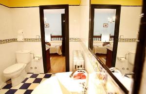W łazience znajduje się toaleta, umywalka i lustra. w obiekcie Hotel Casa de Indianos Don Tomás w mieście Nueva de Llanes
