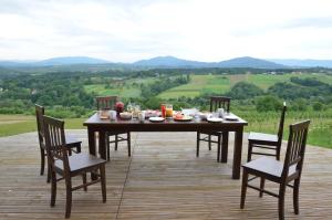 a table and chairs on a deck with a view at Fantastic View Vineyard Beskid Mountains in Gruszów
