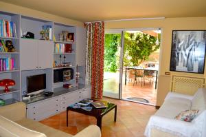 a living room with a couch and a tv at Casa Magnolia in Gravina di Catania