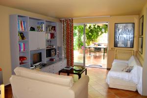 uma sala de estar com um sofá e uma televisão em Casa Magnolia em Gravina di Catania