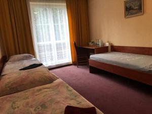 a room with two beds and a table and a window at Chata Rosa in Malenovice