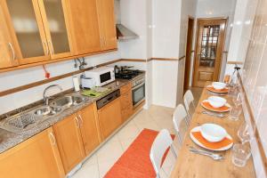 eine Küche mit Spüle und Tisch mit Stühlen in der Unterkunft Da Ponte Flats - Armacao De Pera Orange Apt in Armação de Pêra + 4 Fotos