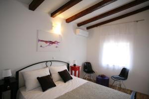 1 dormitorio con 1 cama con 2 sillas y una ventana en Rooms Beljan, en Trogir