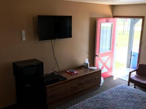 un soggiorno con TV a parete e una porta di Exxon Quik Stop & Motel a Wausaukee