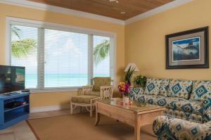 a living room with a couch and a table at Cape Santa Maria Beach Resort & Villas in Seymourʼs