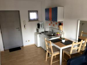 eine kleine Küche mit einem Tisch und eine kleine Küche mit einem Waschbecken in der Unterkunft Apartment Downtown in Regensburg