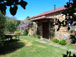 a stone house with a picnic table in the yard at Casa do Retiro in Pedrógão Grande