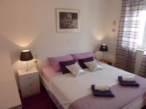 sypialnia z dużym łóżkiem z fioletowymi poduszkami w obiekcie Rita Exclusive Apartments with Parking w mieście Zadar