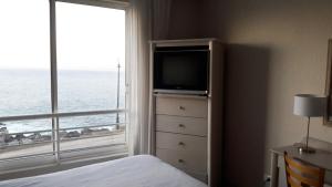 Marparaiso Concon في كونكون: غرفة نوم بسرير ونافذة بها تلفزيون