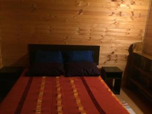 Cama en habitación con pared de madera en Turismo Montaña, en La Ensenada