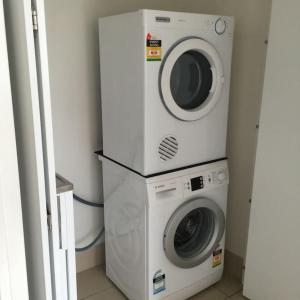 a washing machine and a dryer in a room at Luxury Apartment in Cairns City in Cairns