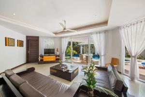 sala de estar con sofá y TV en Lipa Talay Haa - 2 Bed Pool Villa - 1 Minute Walk To Beach, en Lipa Noi