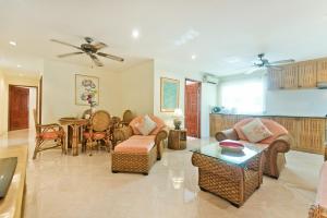 a living room with a couch and chairs and a table at BUTTERFLY GARDEN BOUTIQUE RESIDENCES Apts and villas, A Lifestyle Destination Ex Lg 1-3 bedroom units , Full kitchen, 2 Full bathrooms, Rain shower, Spa bath, FREE BBQ, Free fast fiber optic WIFI, Staff 24-7 in Pattaya South