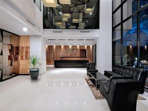 a lobby with black leather chairs and a waiting room at Hotel Neo Gajah Mada Pontianak by ASTON in Pontianak